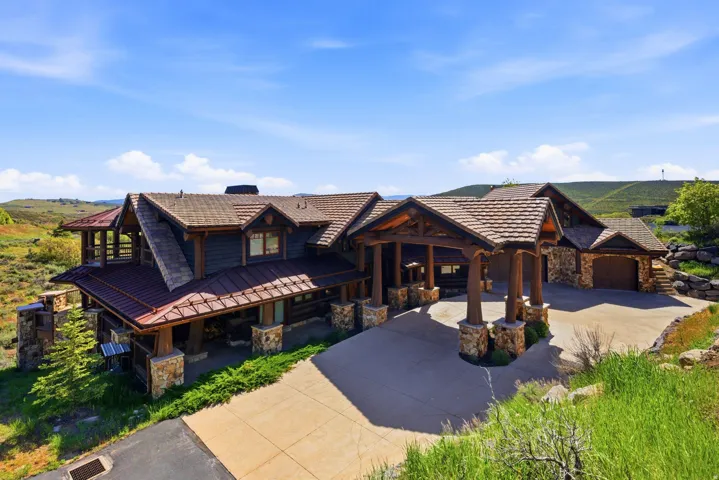 Rustic-inspired architecture featuring a multi-gabled roofline with copper and wood-shingle roofing materials