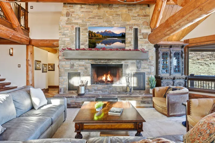 Stone fireplace with a concrete mantel, flanked by a built-in wood cabinet