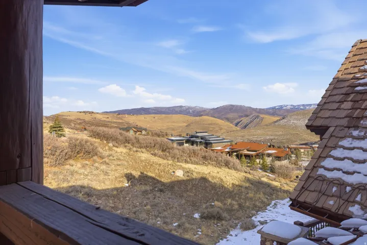Expansive mountain landscape with distant homes and natural vegetation