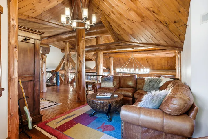 Exposed wood beam construction with a vaulted wood-paneled ceiling