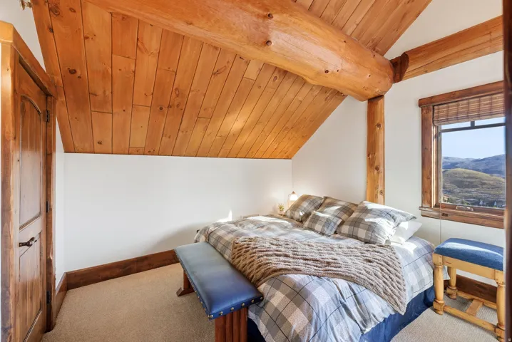 Angled wood-paneled ceilings with exposed log beams