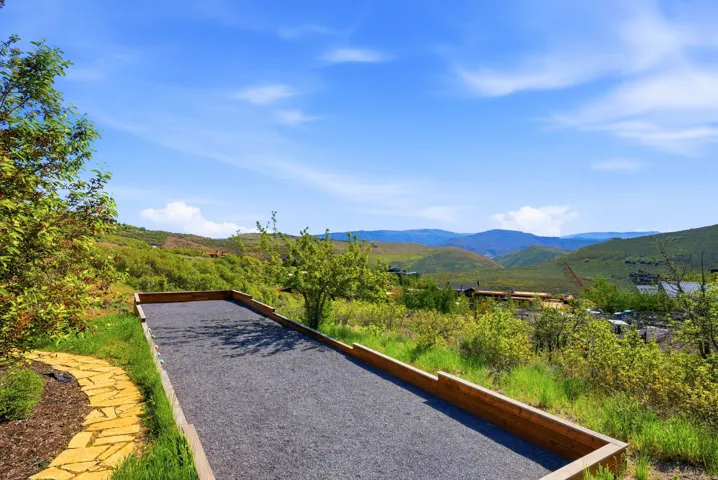 Outdoor bocce ball court with wooden borders and a gravel surface