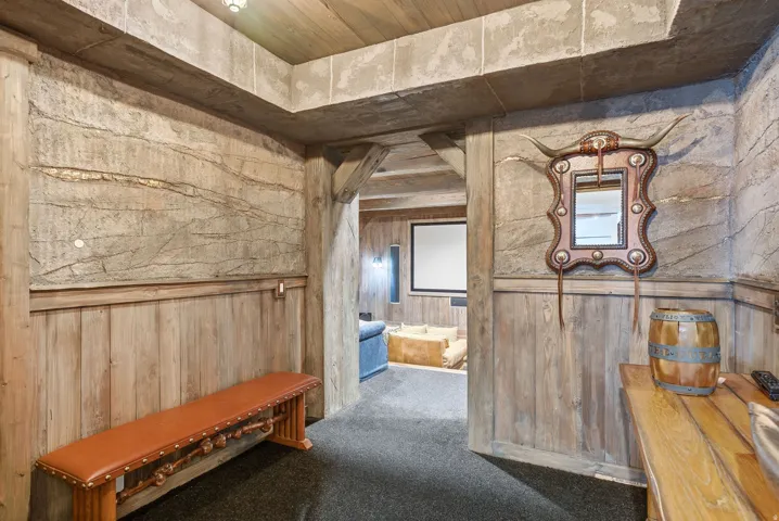 Textured wall finishes with wood wainscoting and coordinating wood ceiling beams create a distinct aesthetic