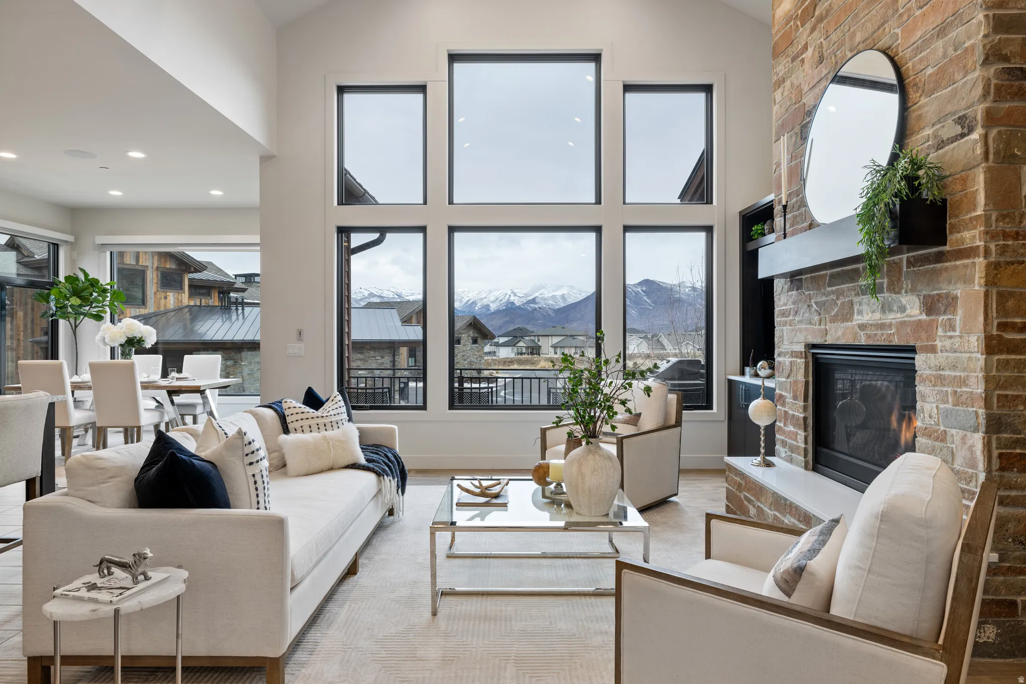 Living area featuring a large fireplace, a mountain view, high vaulted ceiling, wood finished floors, and recessed lighting
