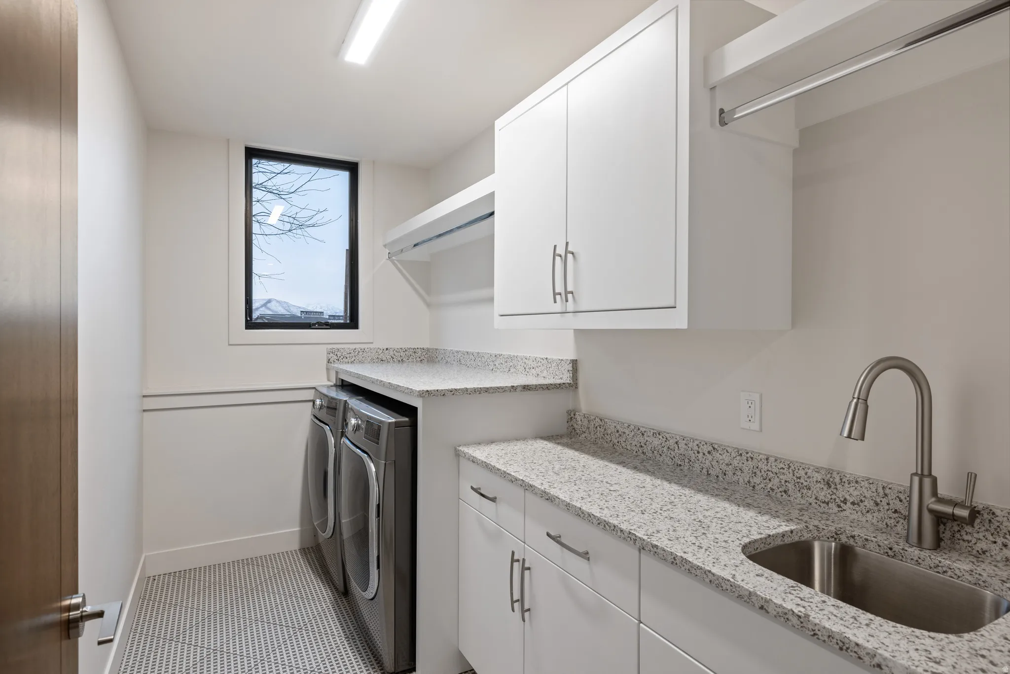 Laundry area featuring cabinet space, independent washer and dryer, and light tile patterned flooring