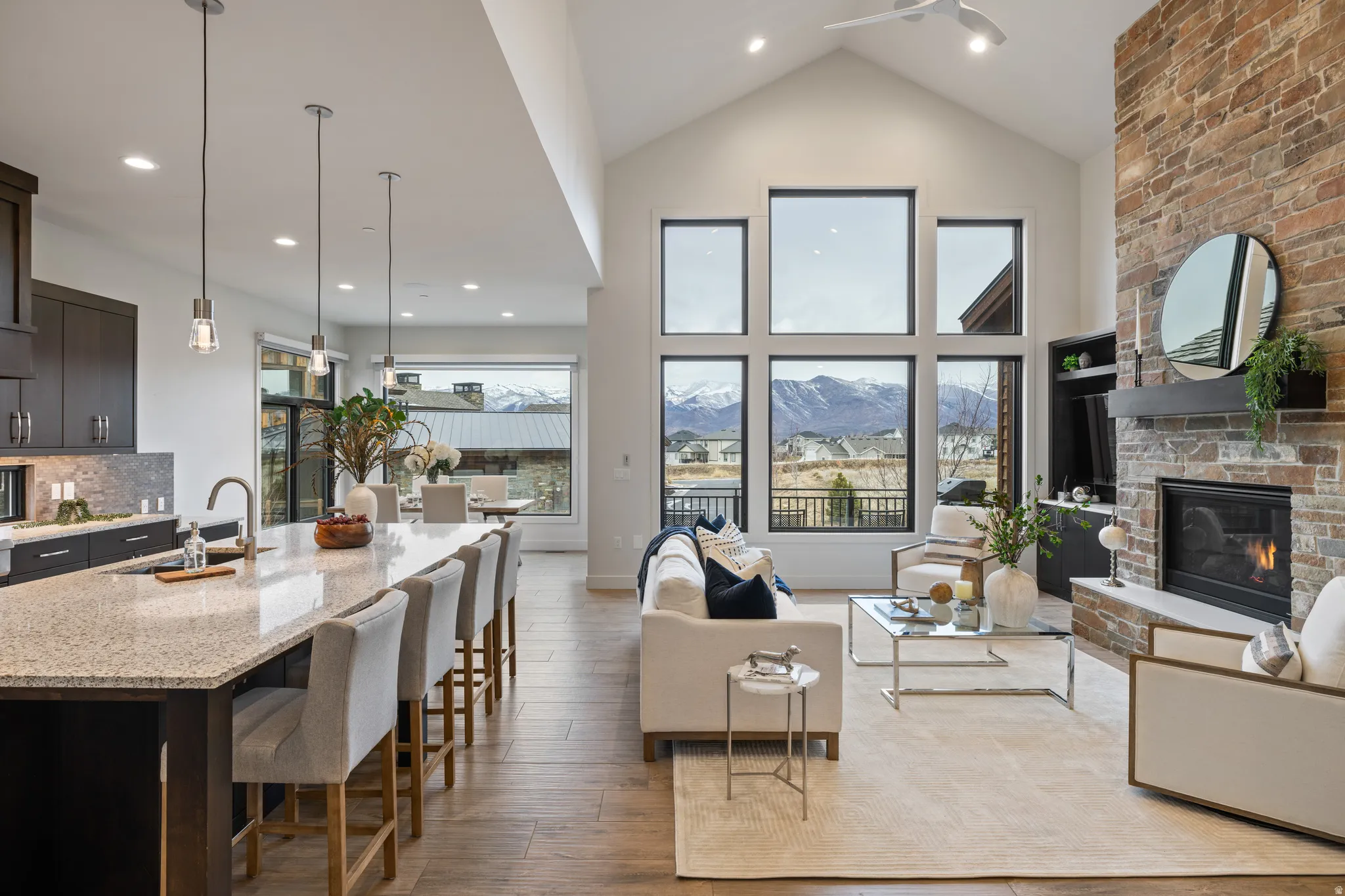 Living room with a large fireplace, wood-type flooring, recessed lighting, and high vaulted ceiling