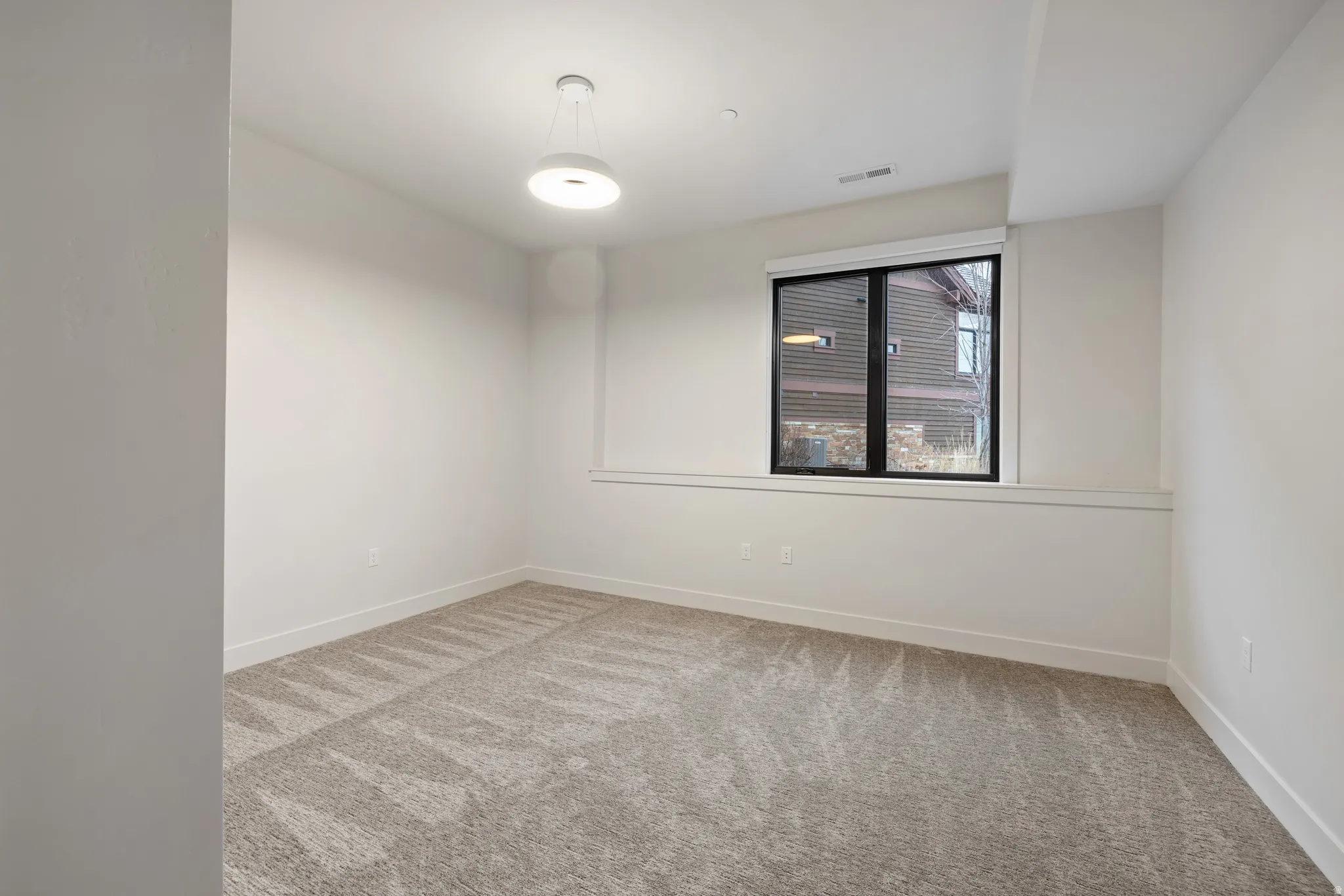 Spare room with light colored carpet and baseboards