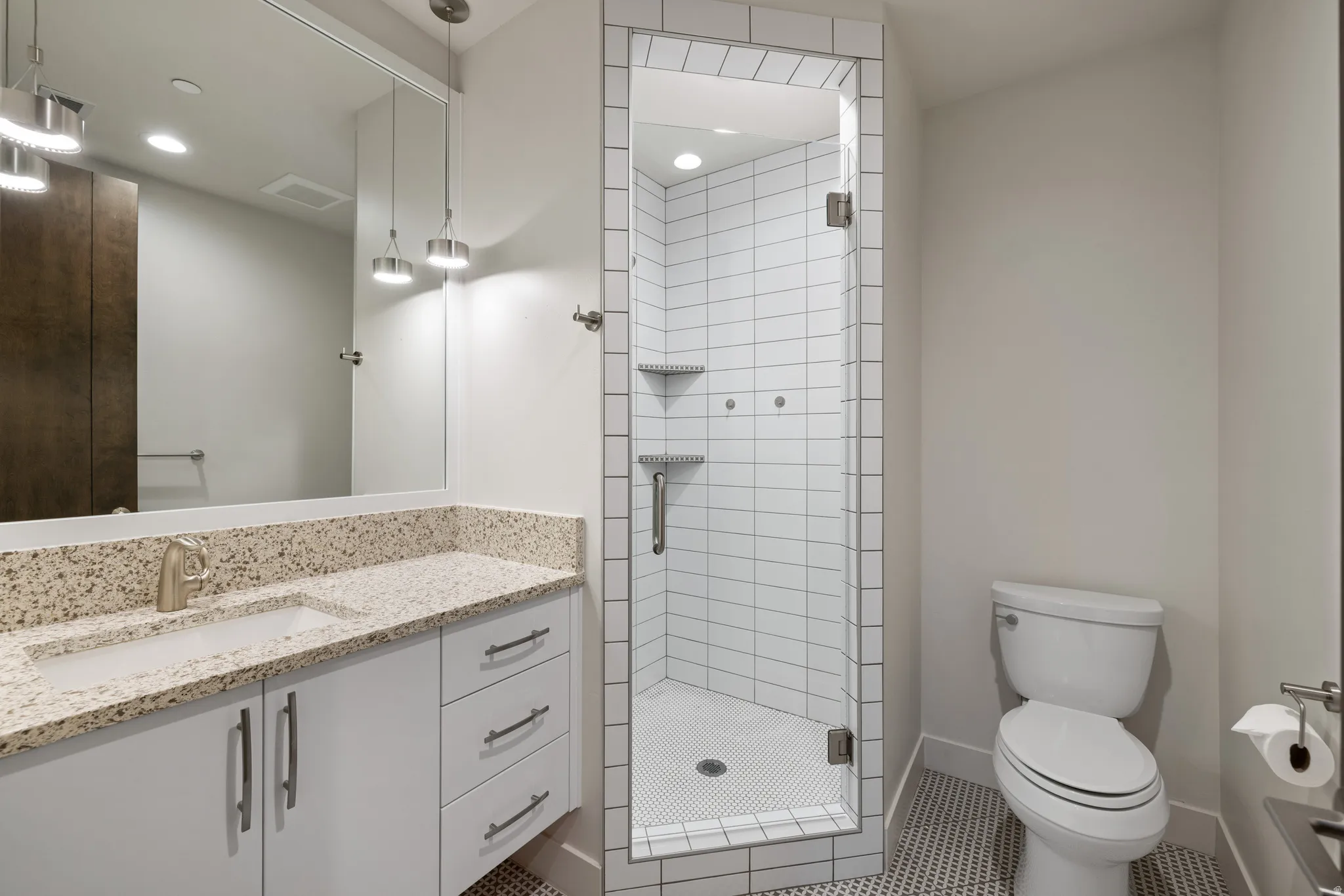Bathroom with a stall shower, vanity, and tile patterned flooring