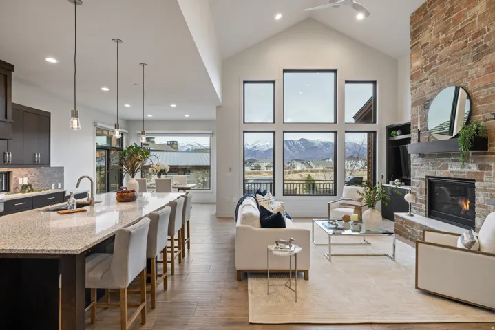 Living room with a large fireplace, wood-type flooring, recessed lighting, and high vaulted ceiling