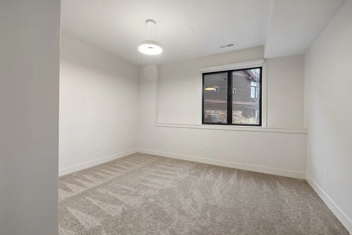 Spare room with light colored carpet and baseboards