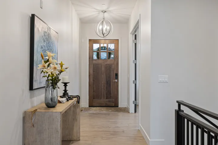 Foyer entrance with light wood-style flooring and a chandelier