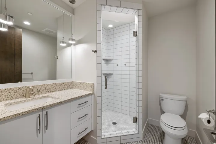 Bathroom with a stall shower, vanity, and tile patterned flooring