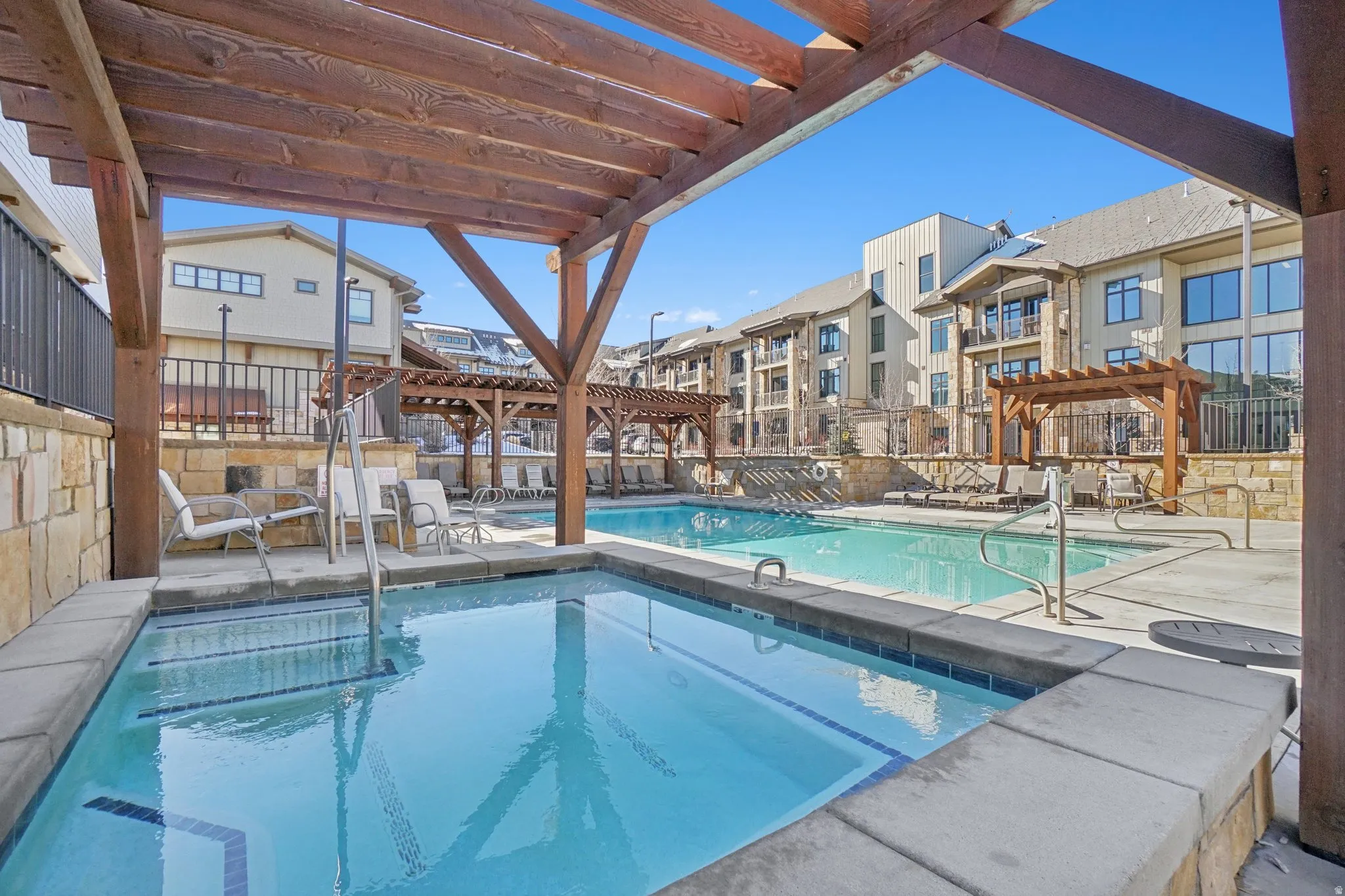Community pool with a pergola and a patio area