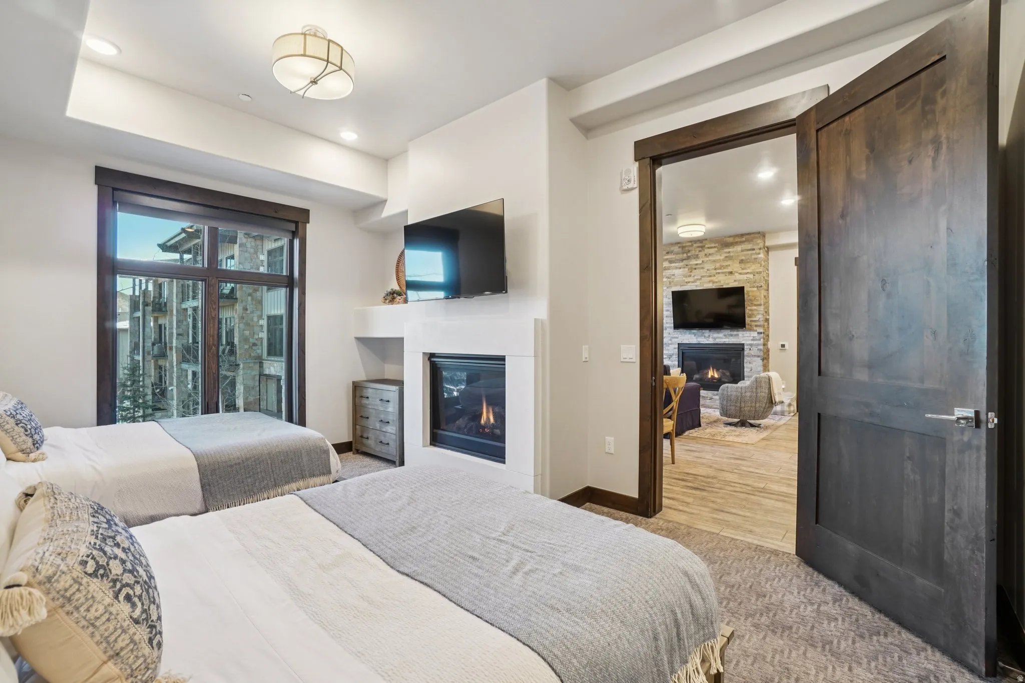 Bedroom with a glass covered fireplace, carpet flooring, and recessed lighting