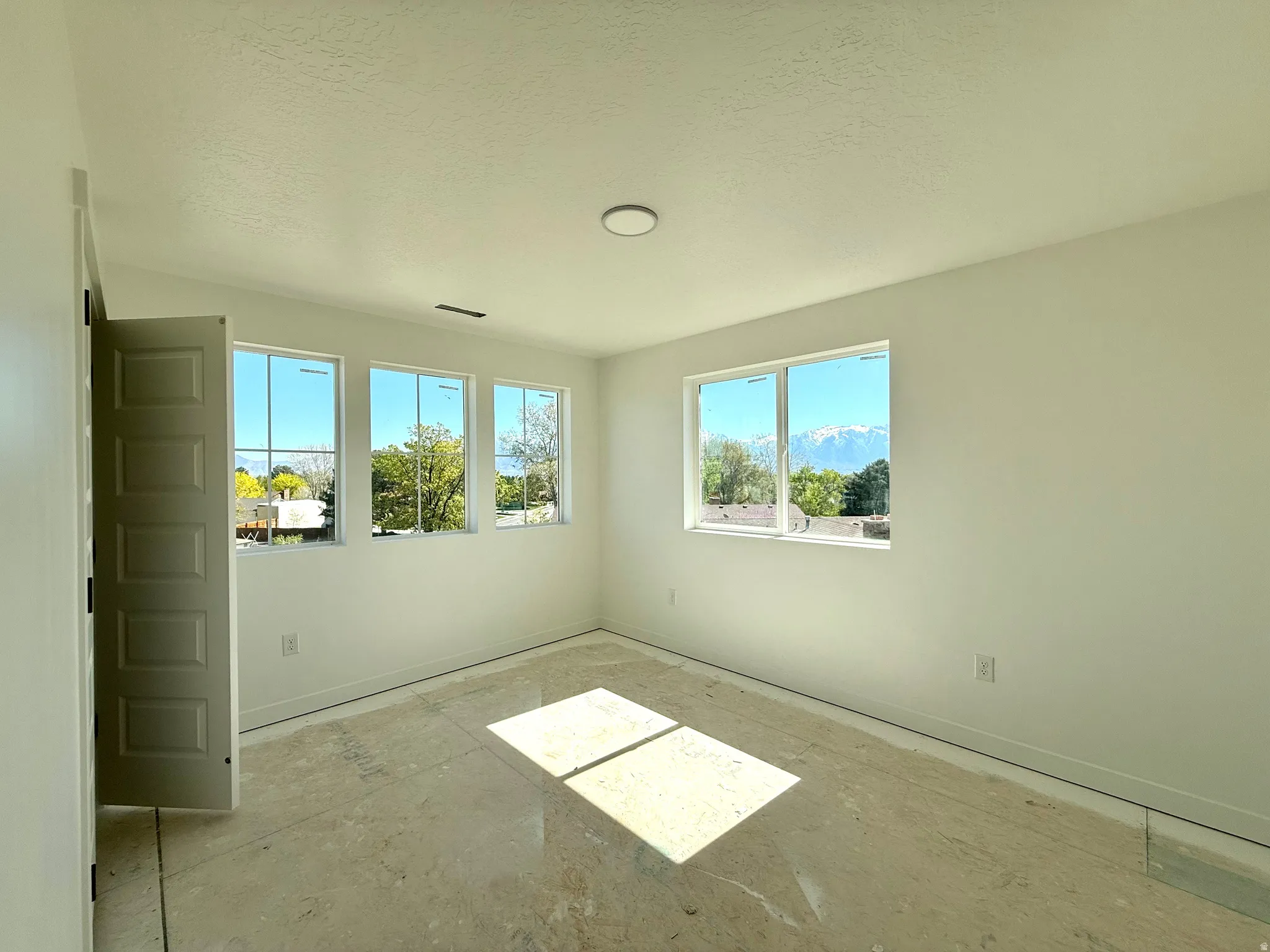Empty room featuring baseboards and a textured ceiling