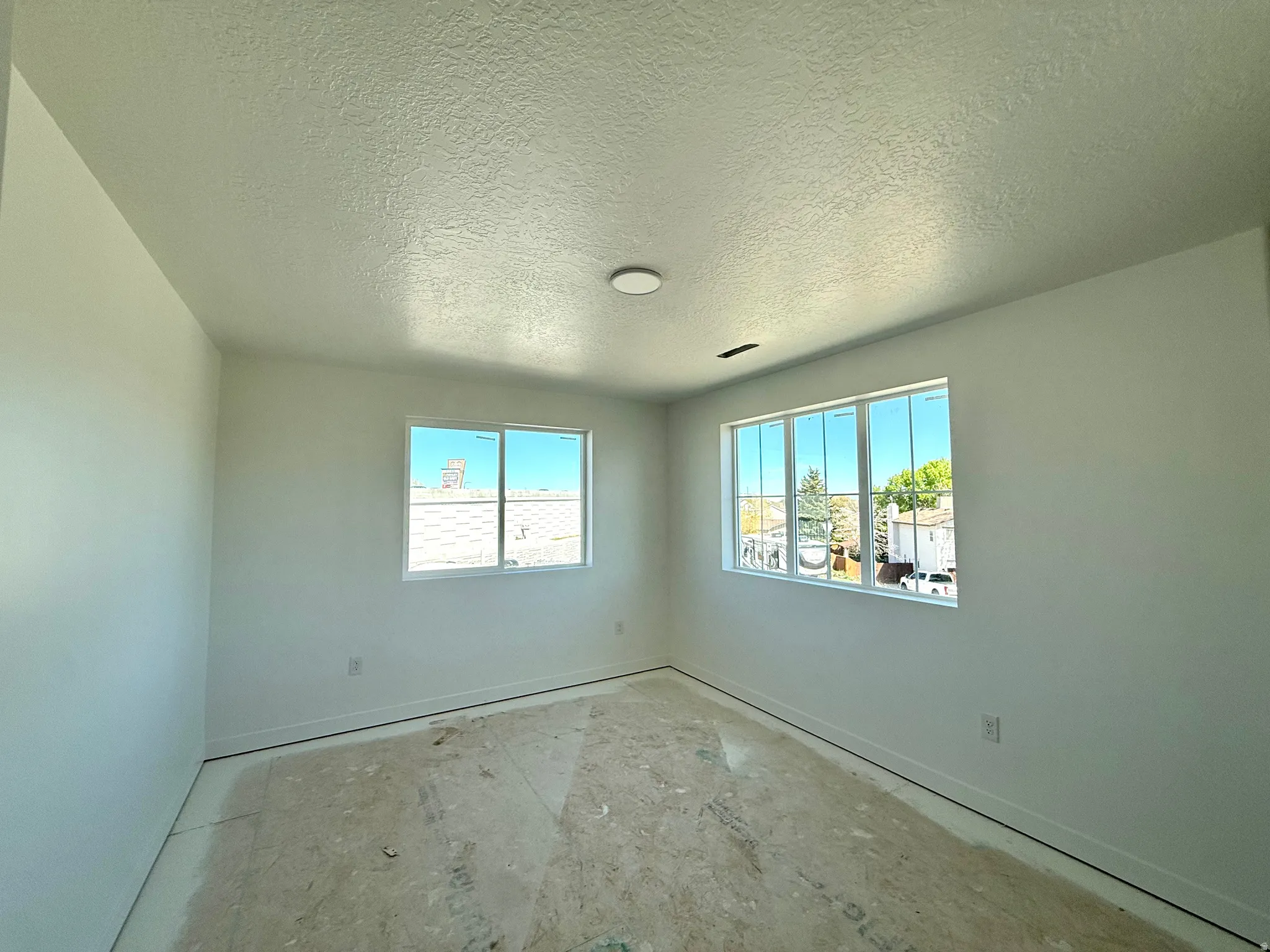 Spare room with a textured ceiling and healthy amount of natural light