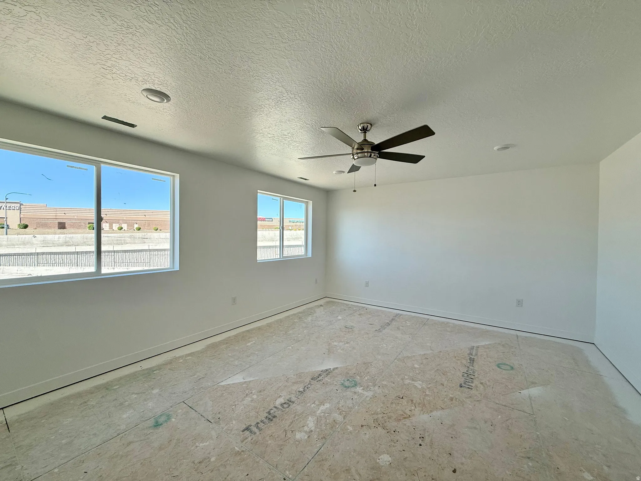 Spare room featuring a ceiling fan and a textured ceiling
