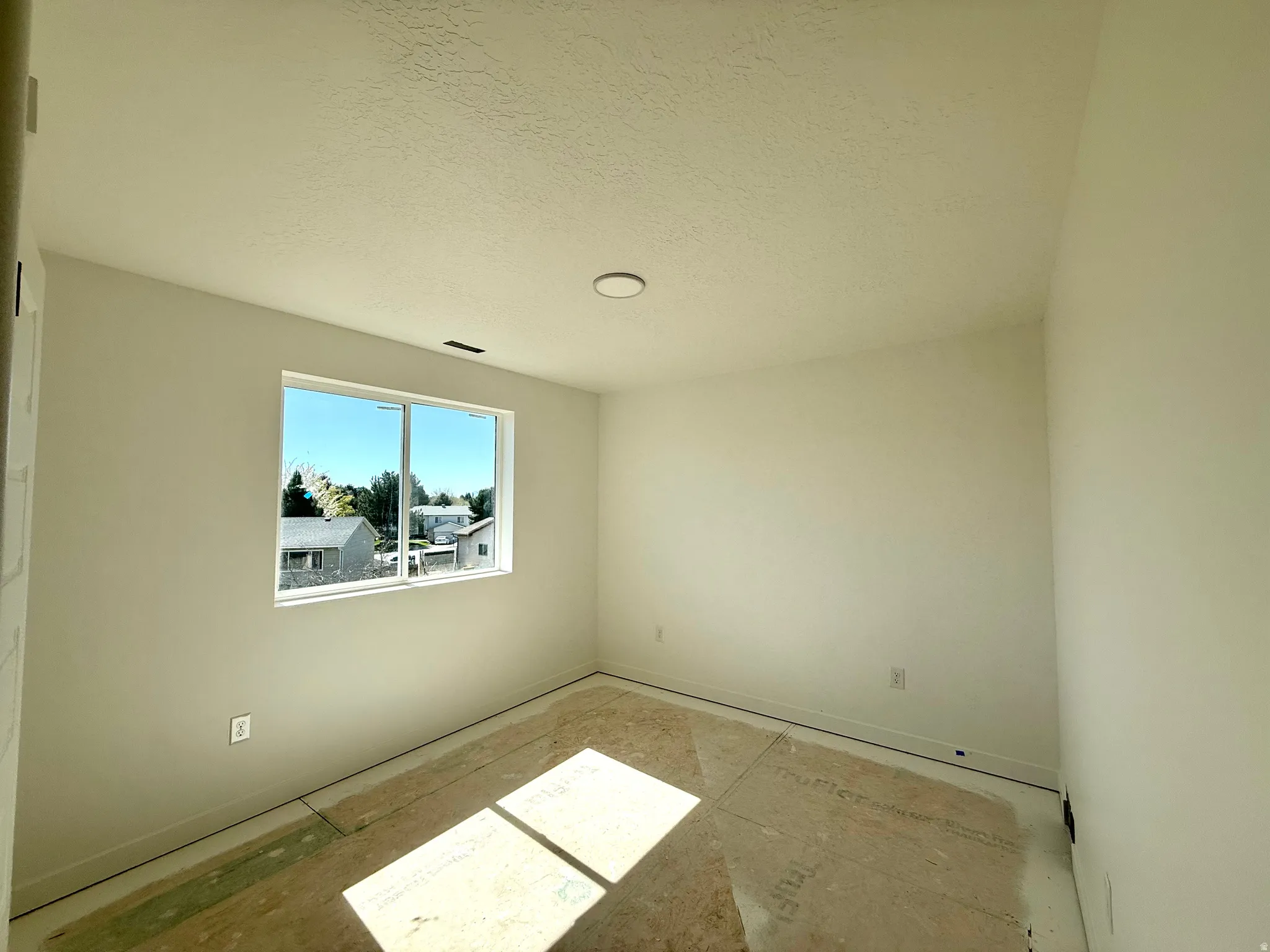 Empty room with a textured ceiling