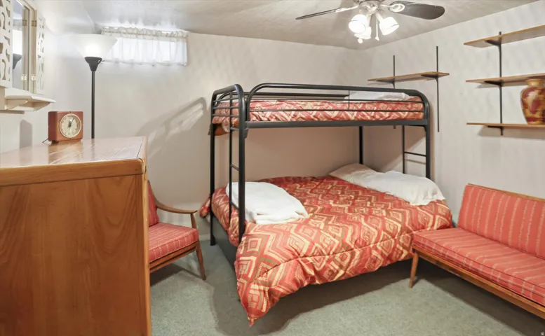 Bedroom with light colored carpet and ceiling fan