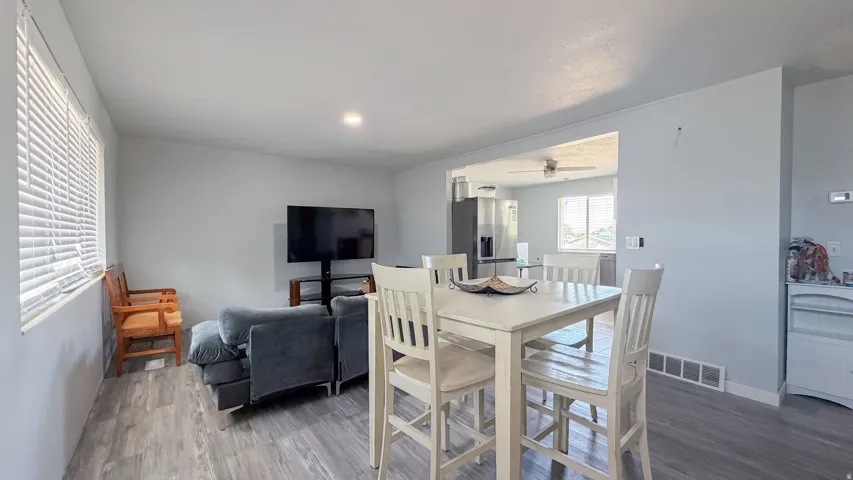 Wood-finish flooring throughout, recessed lighting, and a kitchen pass-through