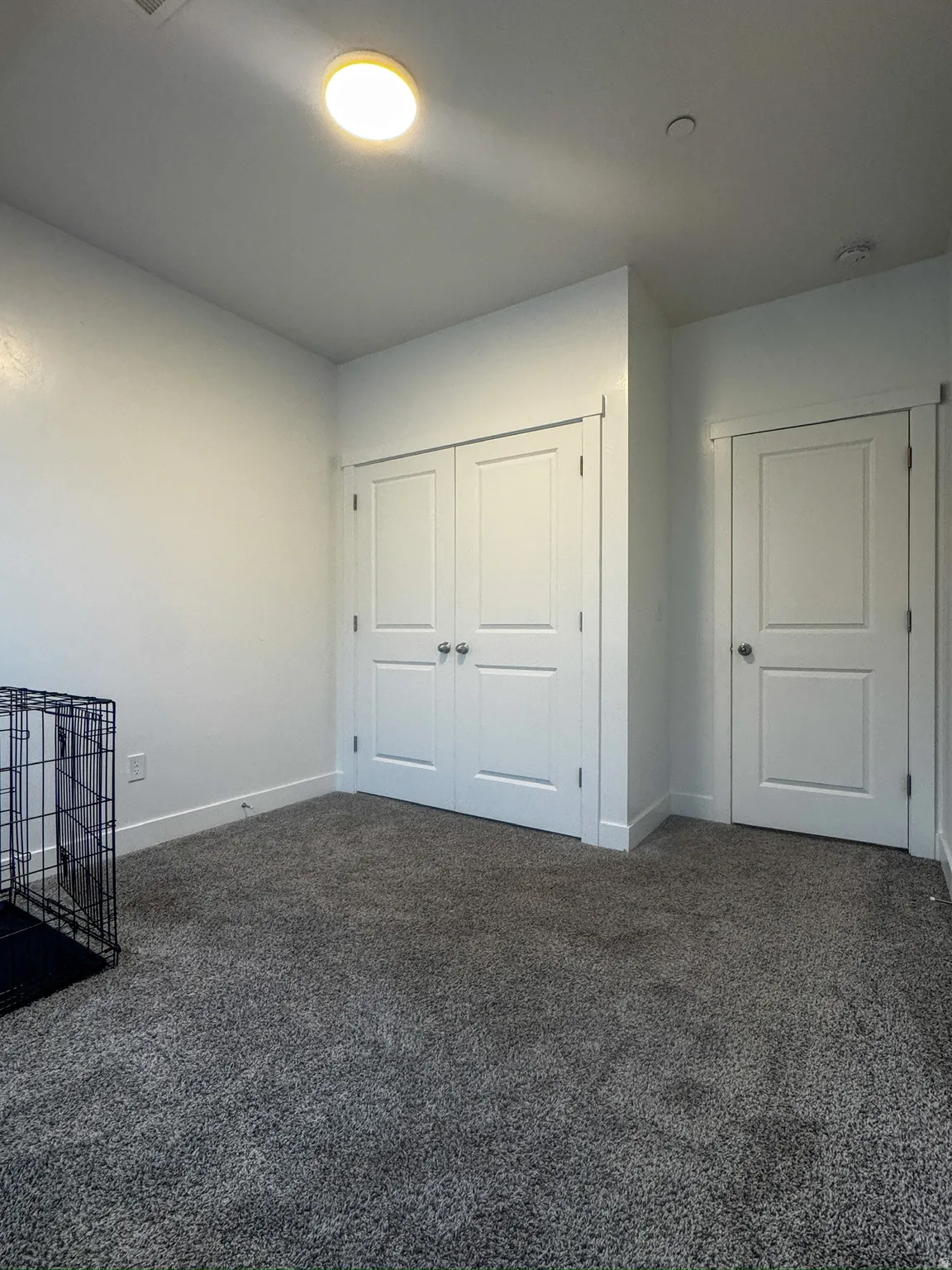 Unfurnished bedroom with dark carpet and a closet