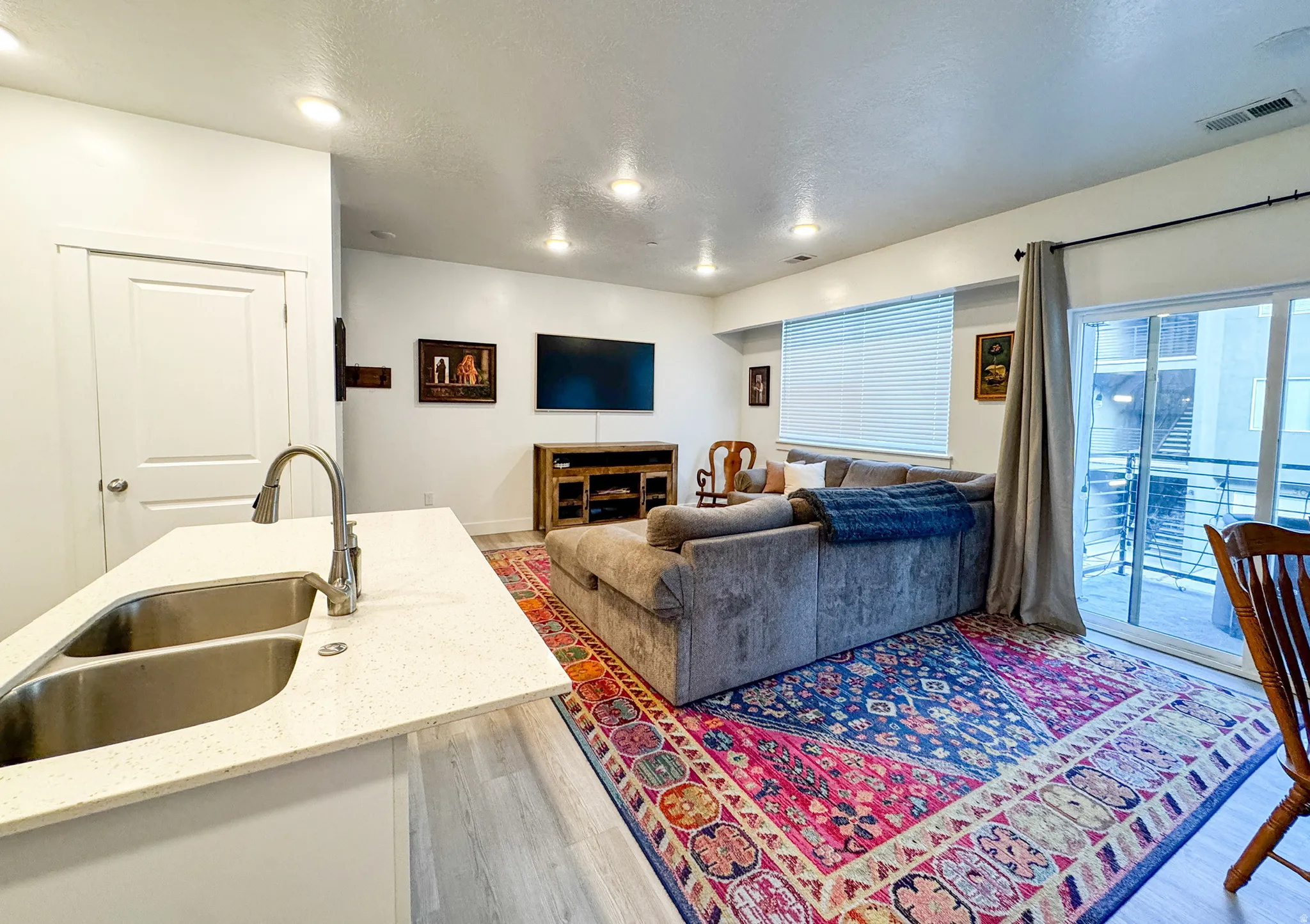 Living area with light wood-style flooring and a textured ceiling