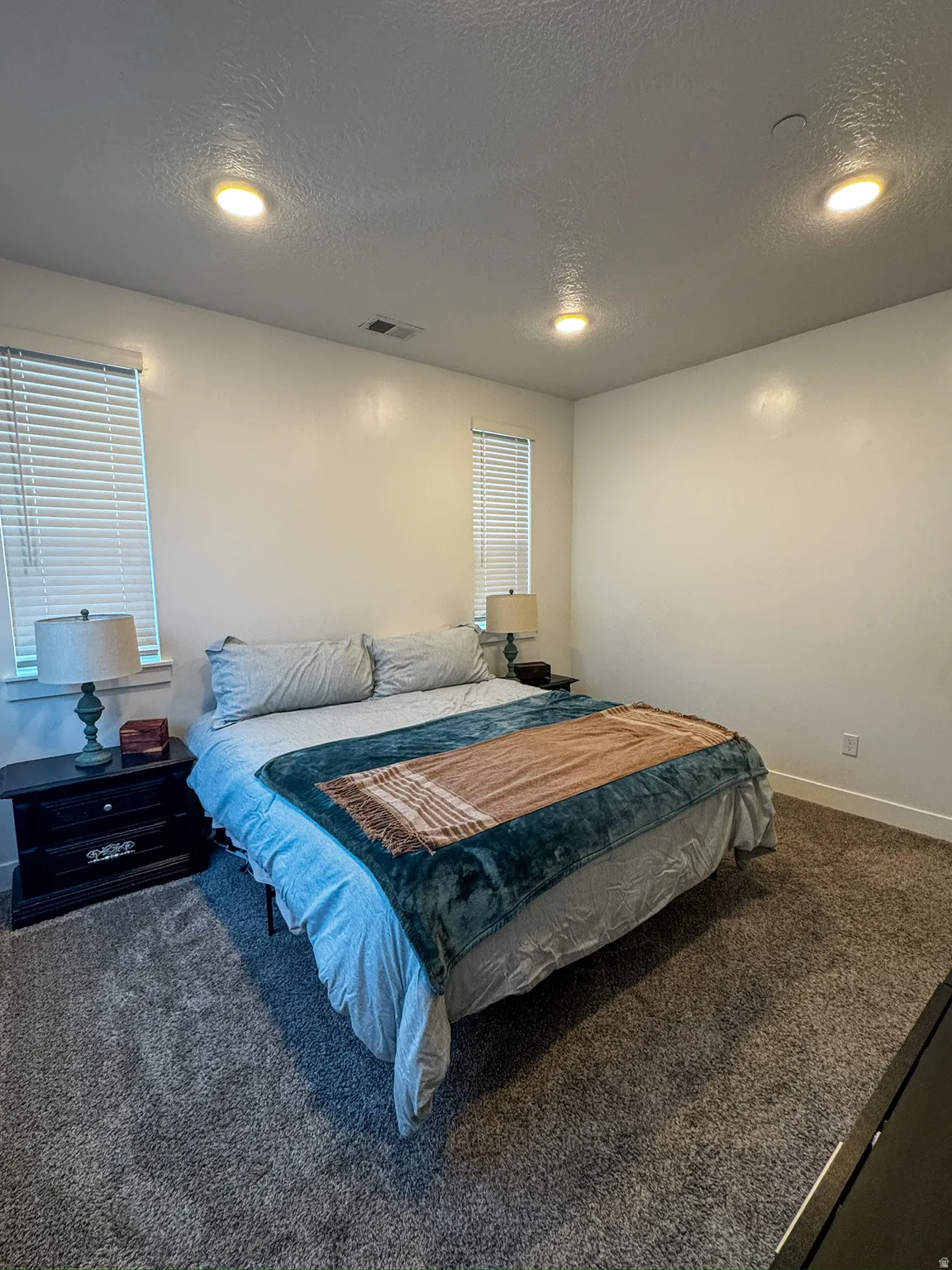 Carpeted bedroom with a textured ceiling