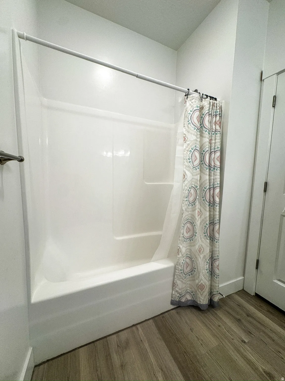 Full bathroom featuring shower / bath combo with shower curtain and dark wood finished floors