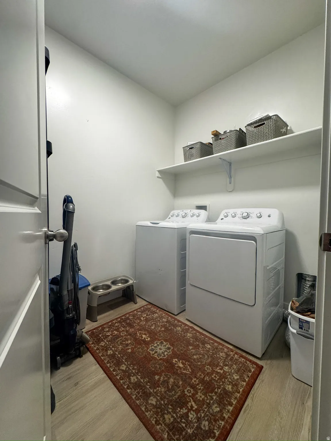 Laundry area with light wood finished floors and independent washer and dryer