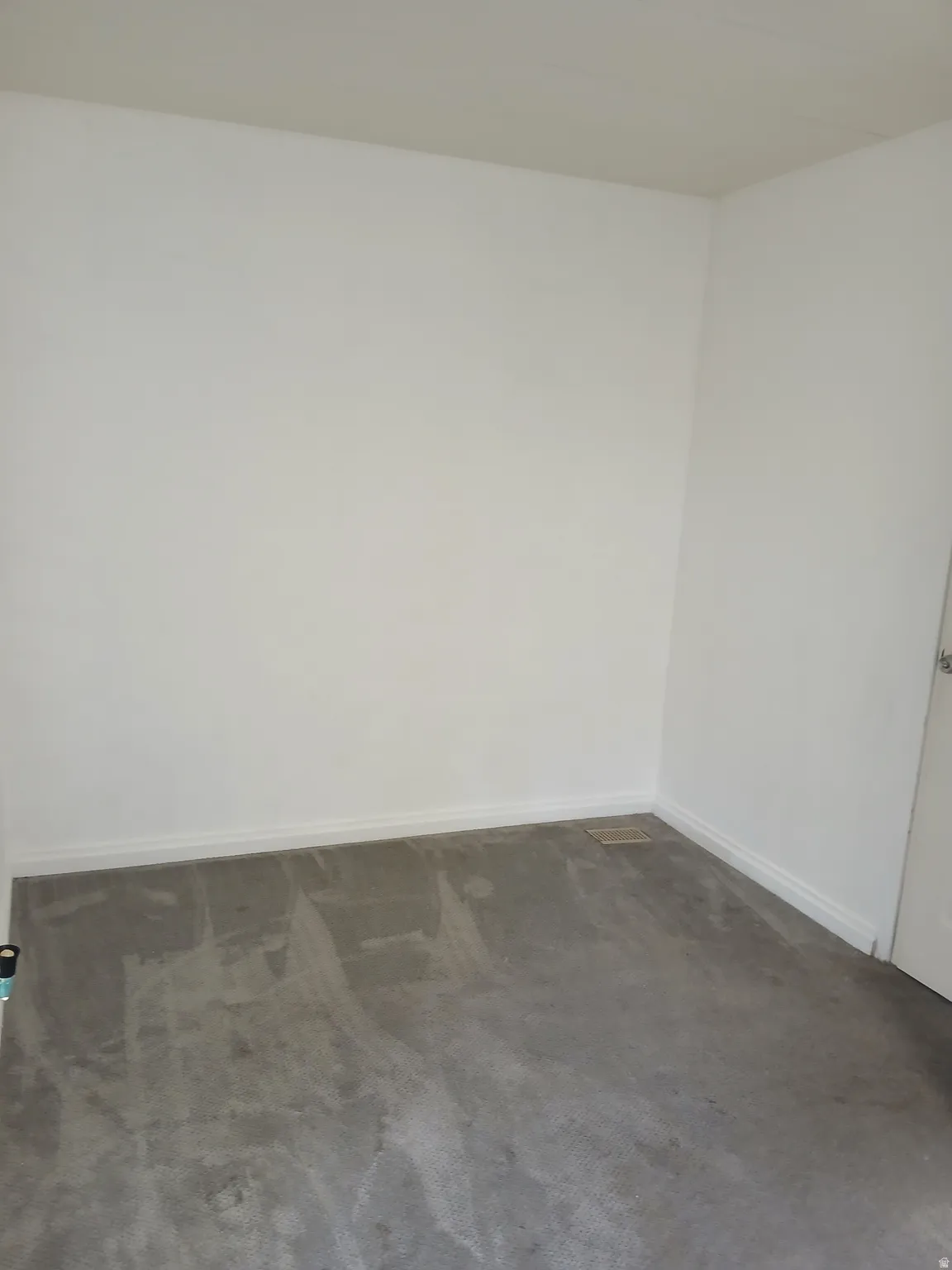 Unfurnished room featuring dark colored carpet and baseboards