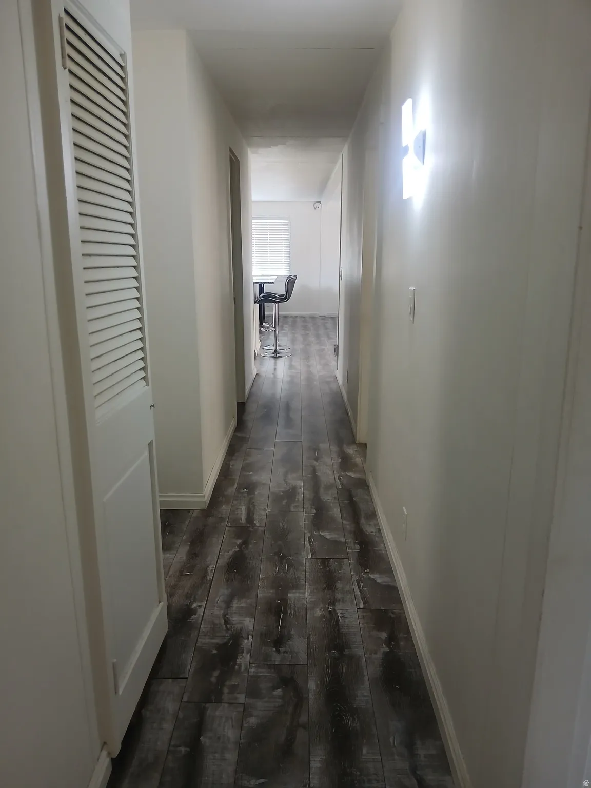 Hall featuring dark wood-type flooring and baseboards