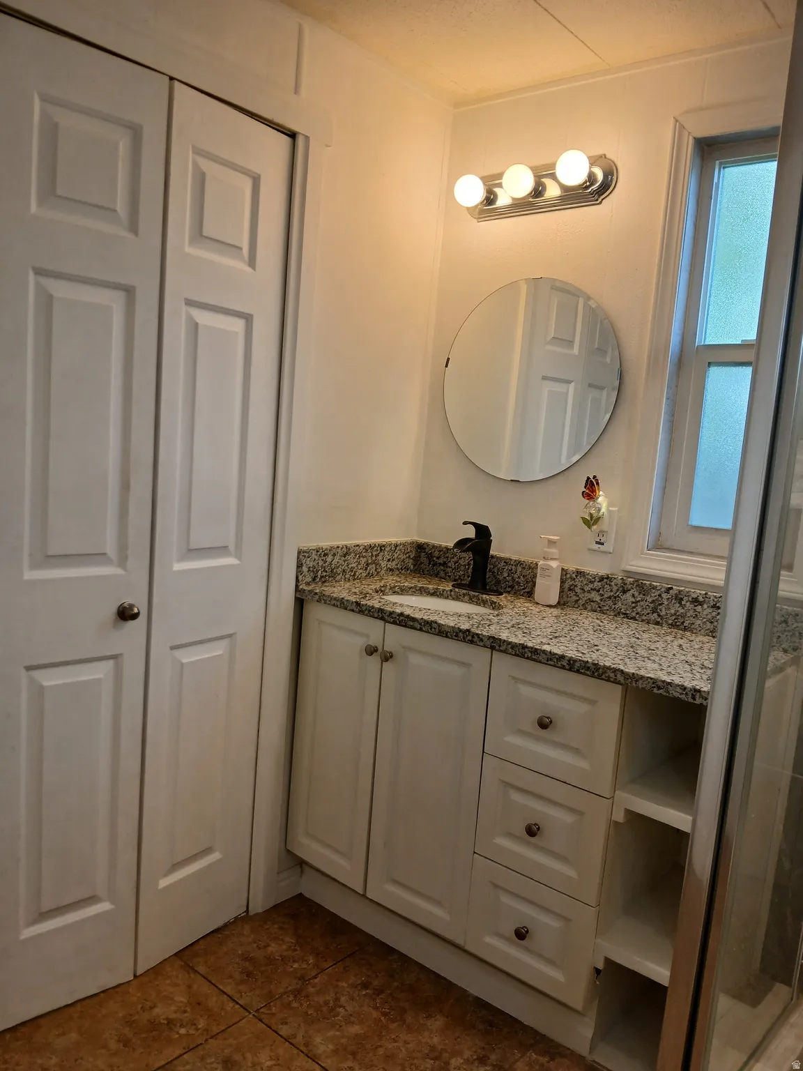 Bathroom featuring vanity and dark tile patterned floors