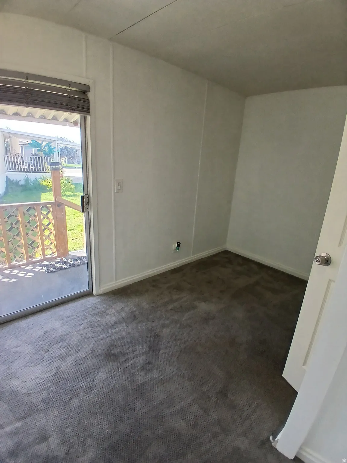 Unfurnished room featuring dark carpet and baseboards