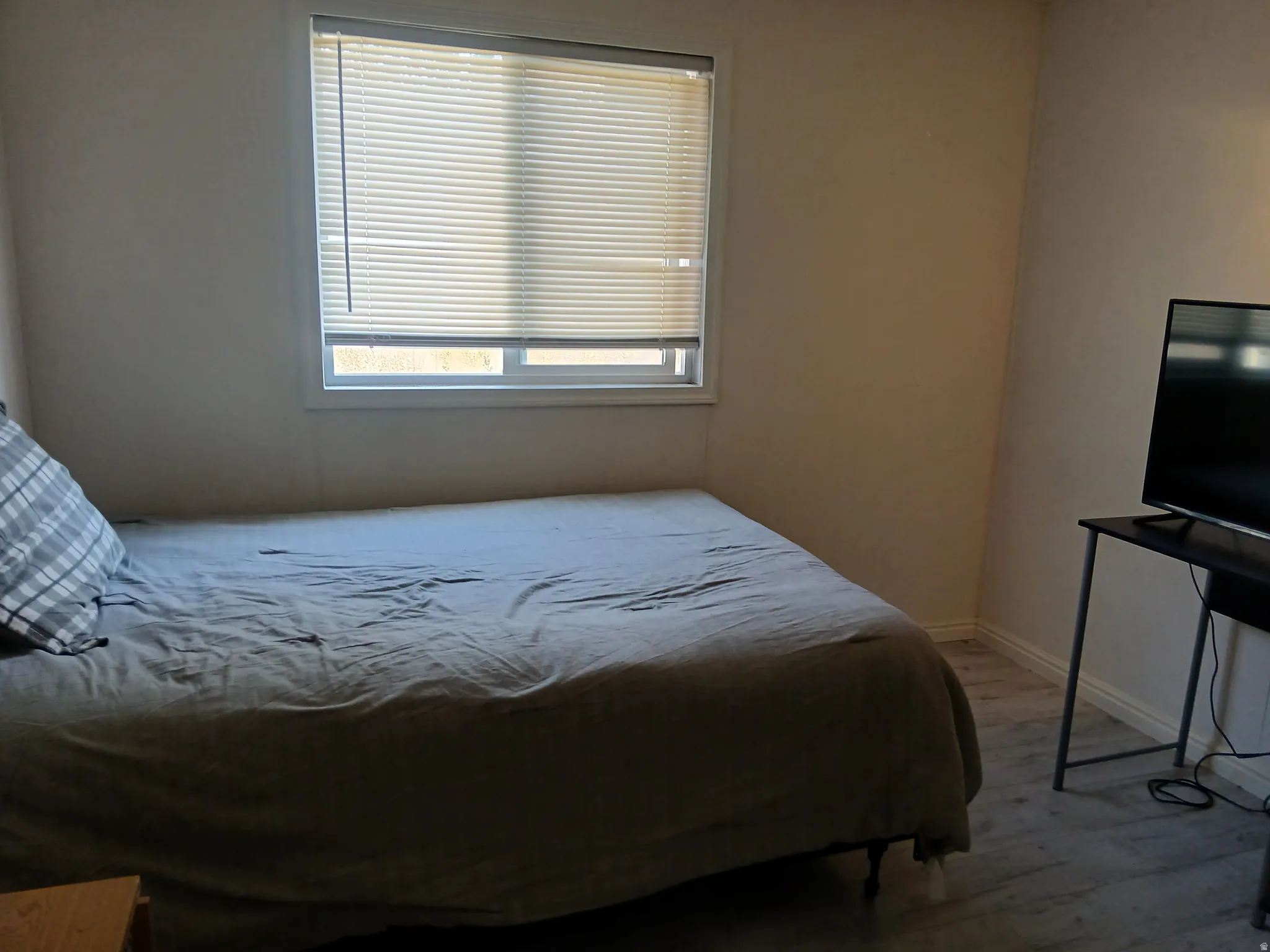 Bedroom with wood finished floors and multiple windows