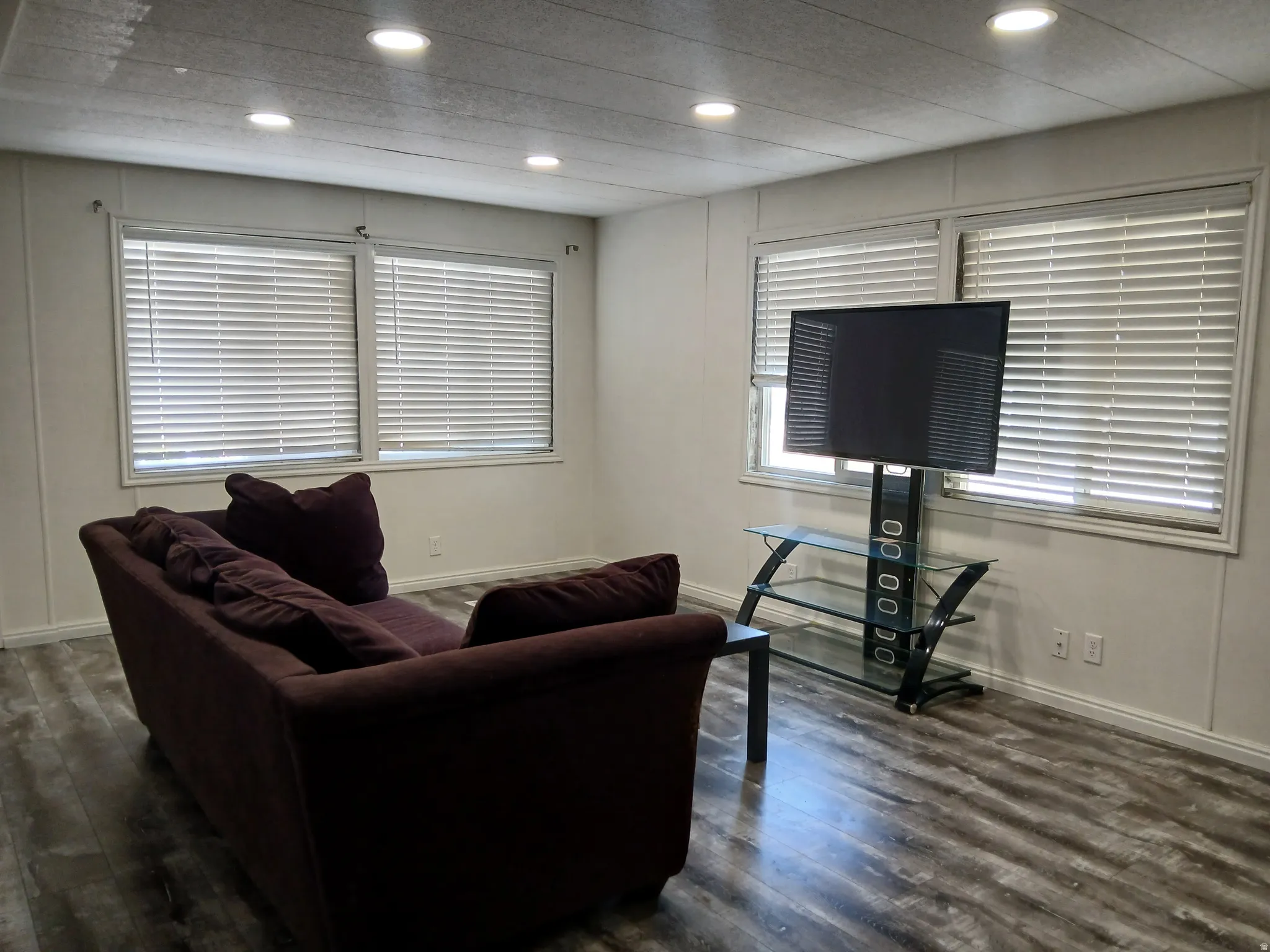Living room with dark wood finished floors and recessed lighting