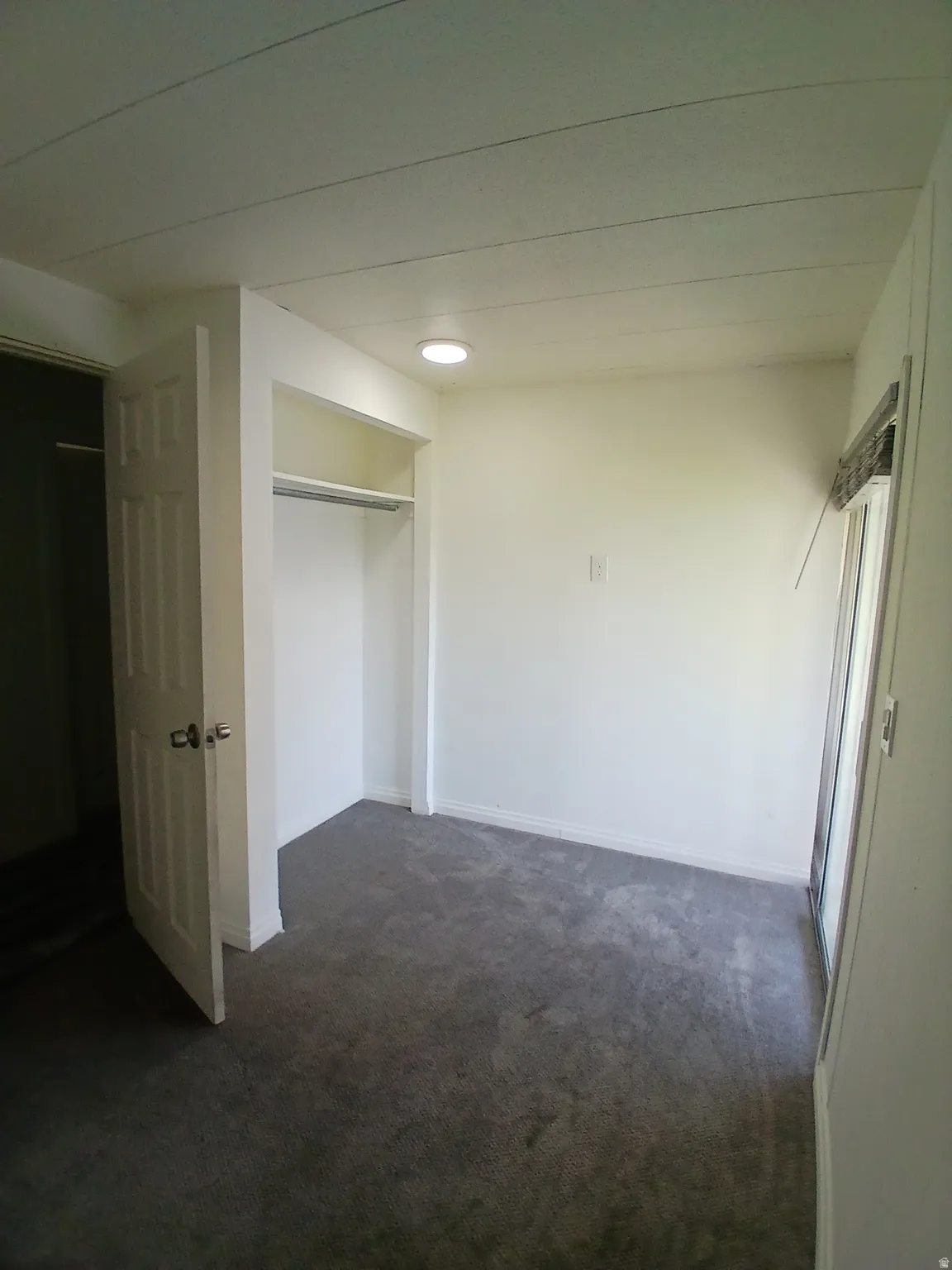 Unfurnished bedroom featuring a closet and dark carpet