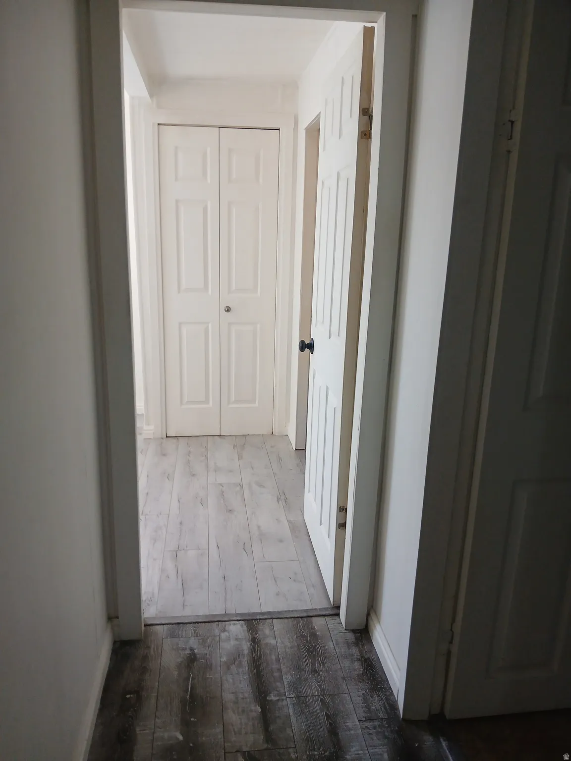Corridor with hardwood / wood-style flooring and baseboards