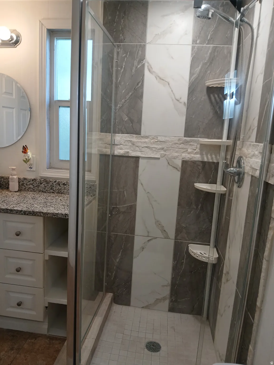 Bathroom with a marble finish shower and vanity