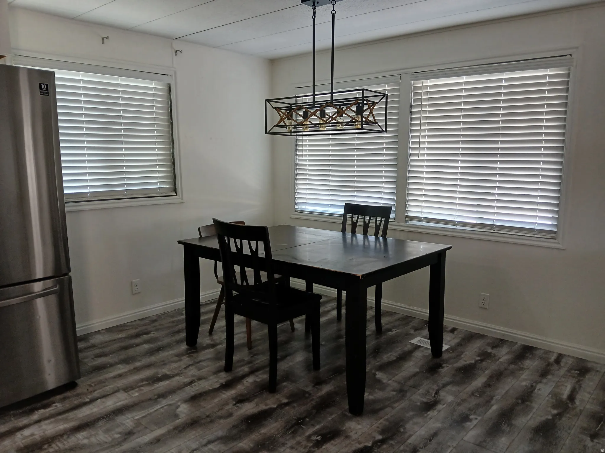 Dining room featuring dark wood-type flooring and baseboards