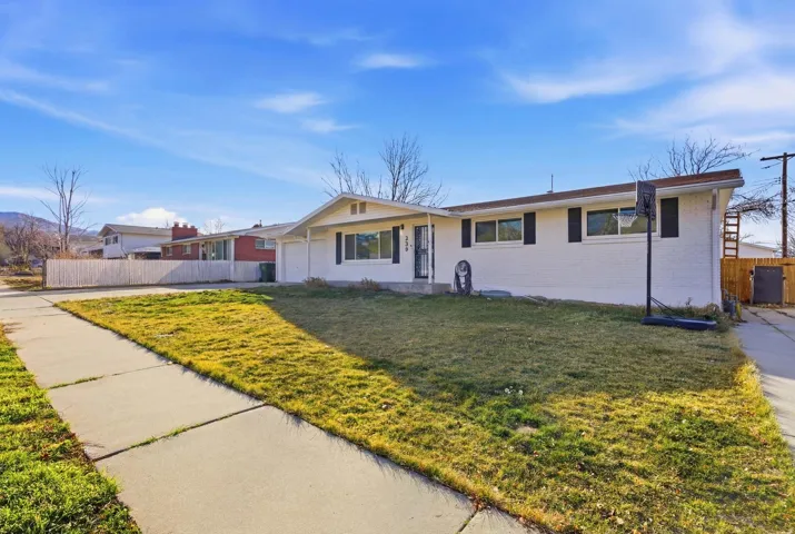 Single story home with brick siding, an attached garage, and driveway
