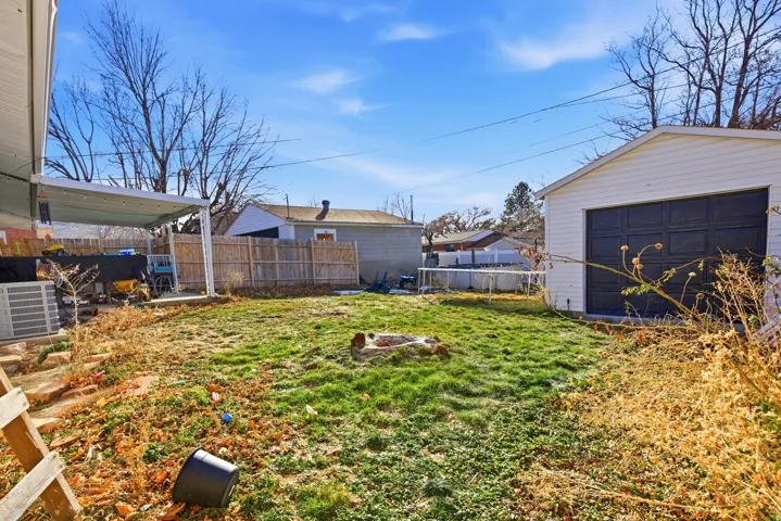 Fenced backyard with an outdoor fire pit and a patio area