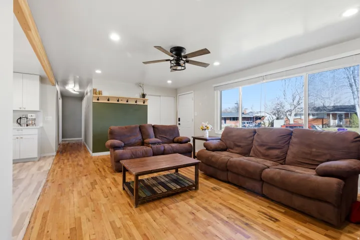 Living room with light wood-style flooring, ceiling fan, and recessed lighting