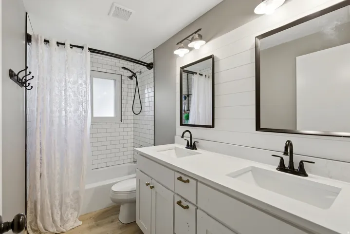 Full bath with shower / bathtub combination with curtain, double vanity,