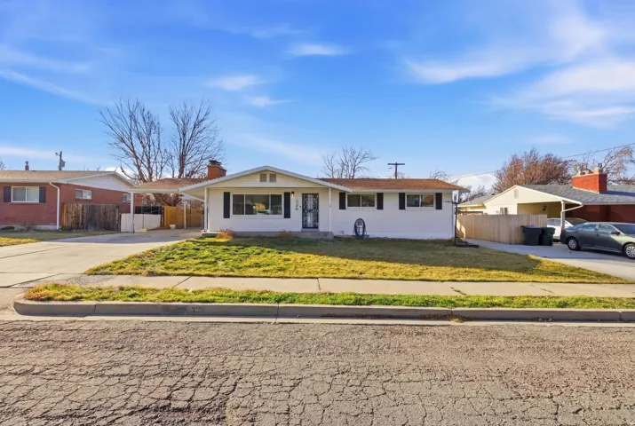 Ranch-style home with concrete driveway and a chimney