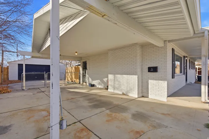 View of patio / terrace with an attached carport and an outbuilding
