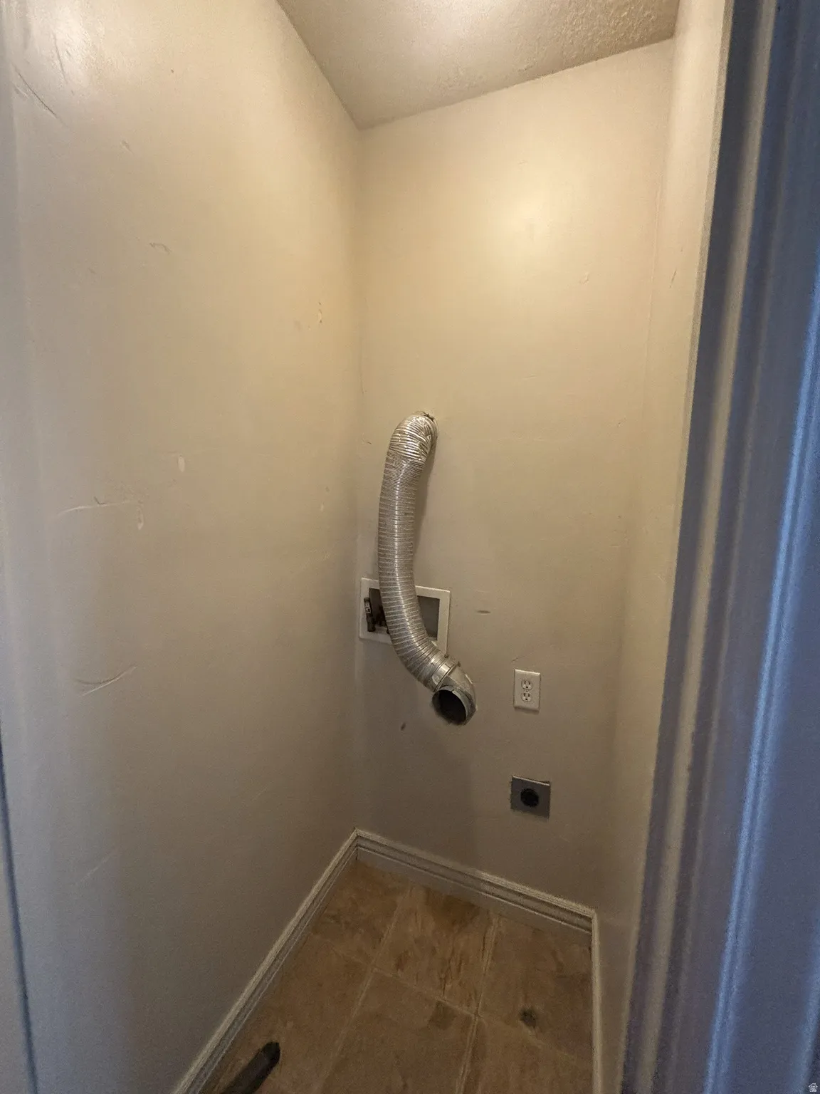 Washroom with light tile patterned flooring and electric dryer hookup