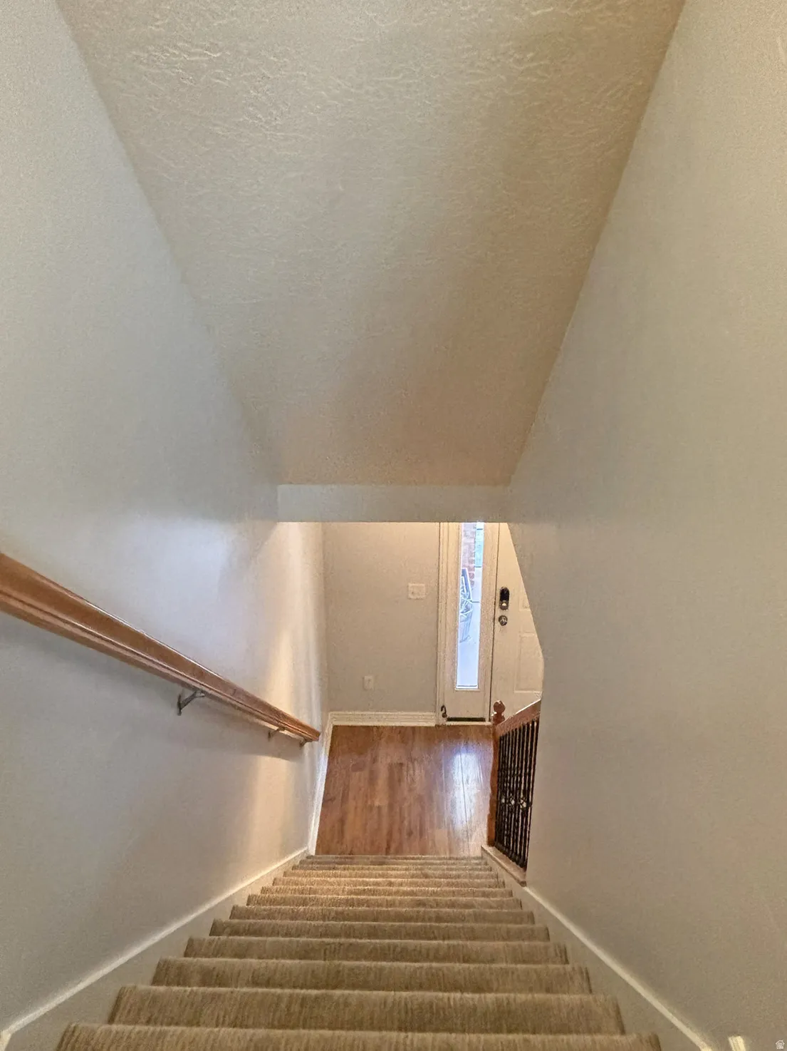 Stairway featuring wood finished floors and a textured ceiling