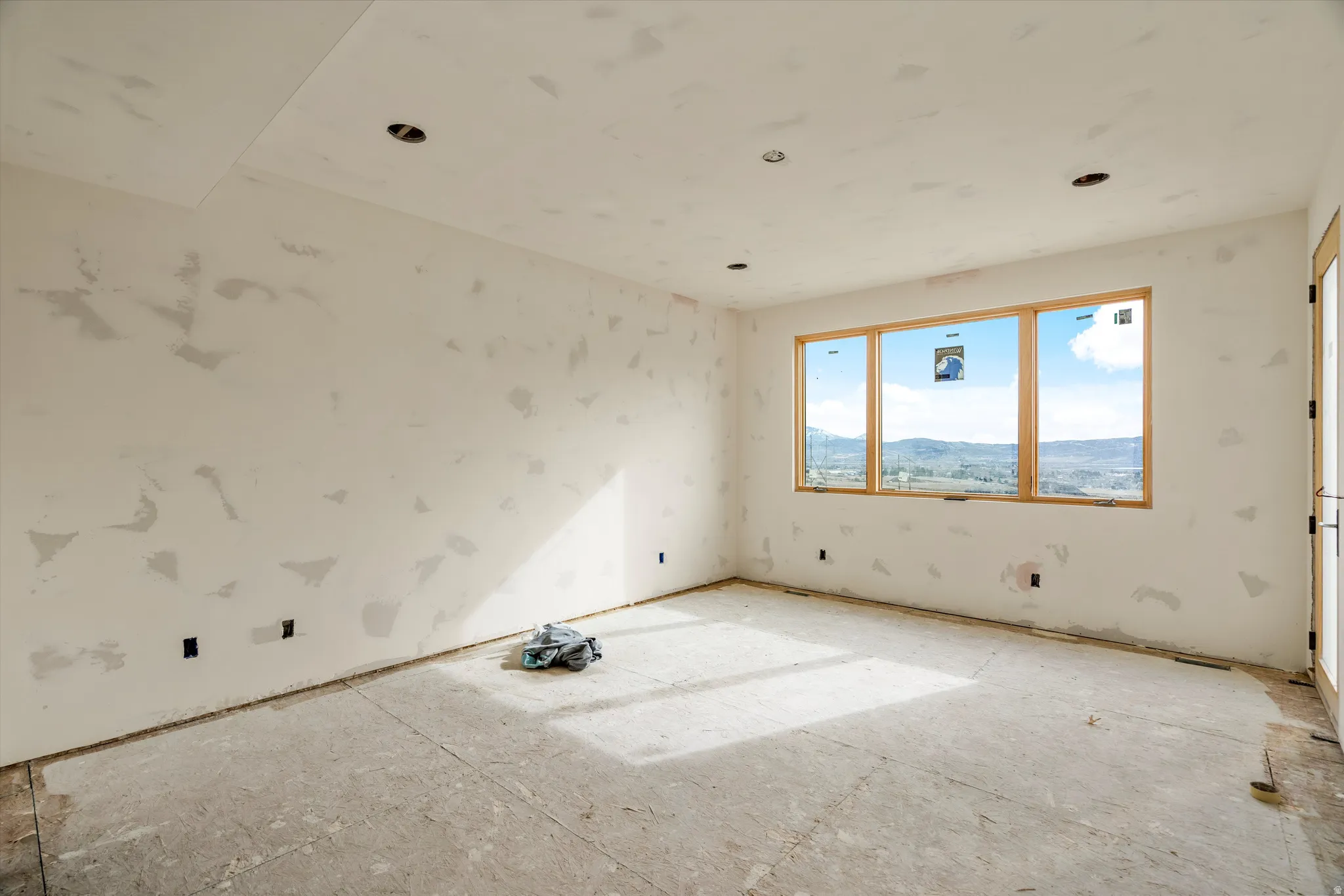 Spacious room with large triple-pane windows showcasing expansive mountain scenery