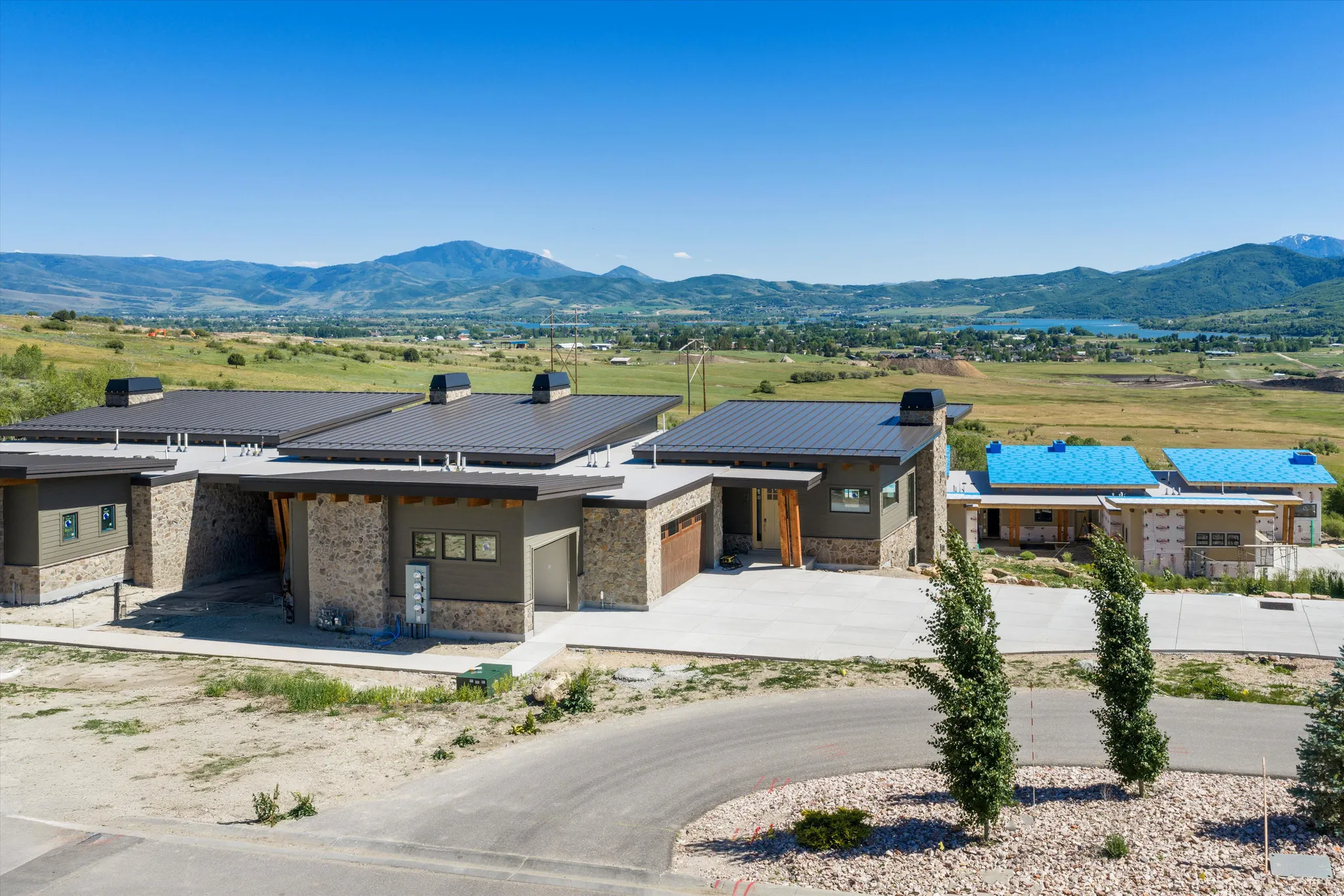 Contemporary exterior featuring a metal roof, stone veneer, and stucco siding
