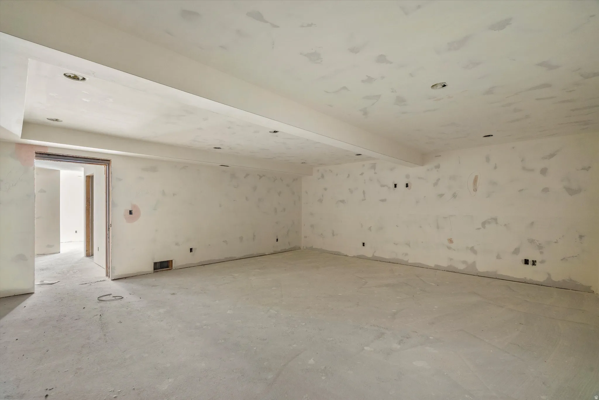 Spacious unfinished interior area with a concrete floor, recessed lighting, and multiple wall outlets